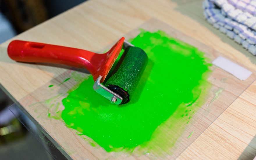 Roller with paint/medium ready for lino block printing